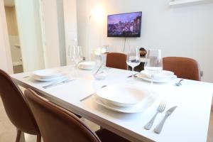 a table with chairs and plates and wine glasses at Puerta de Arcos in Arcos de la Frontera