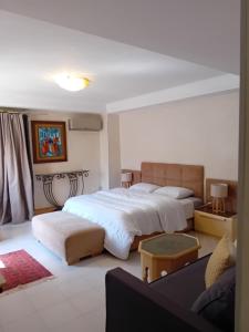 a bedroom with two beds and a couch at Le havre de paix in Marrakesh