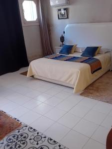 a bedroom with a bed and a white tiled floor at Le havre de paix in Marrakesh