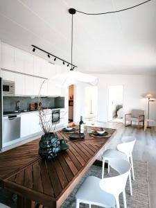 a kitchen and living room with a wooden table and chairs at Vila Karup Modern Scandinavian Holiday Home in Båstad