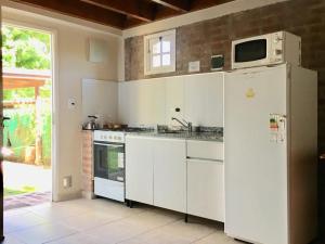 a kitchen with a refrigerator and a microwave at Complejo Aldea Champaqui in Villa General Belgrano