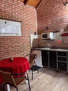 a kitchen with a table and a brick wall at Complejo Aldea Champaqui in Villa General Belgrano