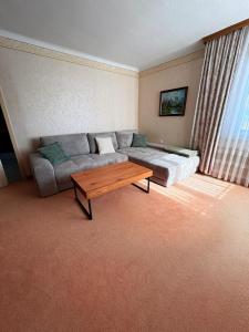 a living room with a couch and a coffee table at Gemütliches Einfamilienhaus mit Garten in Gemeinlebarn