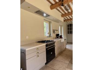 a kitchen with white cabinets and a stove top oven at Villa in Saignon with Pool and Scenic Views in Ménerbes