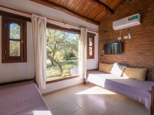 a room with two beds and a window at Sombra de Liebre Casas de Campo en Villa General Belgrano in Villa General Belgrano +52 photos