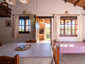 a dining room with a table and some windows at Sombra de Liebre Casas de Campo en Villa General Belgrano in Villa General Belgrano