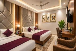 a hotel room with two beds and a desk at Hotel Belwood De Near Delhi Airport IGI in New Delhi +16 photos