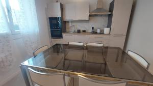a glass table in a kitchen with chairs around it at B&B Montegrappa in Mestrino