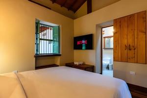 a bedroom with a white bed and a window at Unique Guatapé in Guatapé