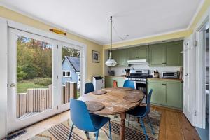 a kitchen with green cabinets and a wooden table and chairs at Antique Charmer Walk to Downtown KBK in Kennebunk