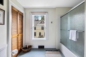 a bathroom with a glass shower and a window at Antique Charmer Walk to Downtown KBK in Kennebunk +28 photos