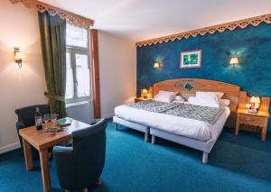 a hotel room with a bed and a table at Hôtel Le Bois Joli in Cauterets