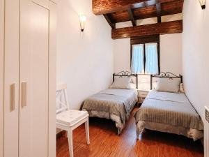 two beds in a room with wooden ceilings and wood floors at Casa Puerta de Albarracín in Albarracín