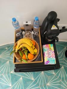 a tray with a basket of fruit and water bottles at Lodgegarden in Aït Bounnit