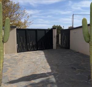 a gate to a house with a cactus at Lodgegarden in Aït Bounnit