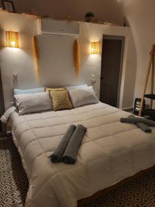 a large white bed with two pillows on it at Lodgegarden in Aït Bounnit
