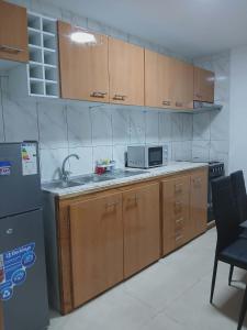 a kitchen with wooden cabinets and a sink and a refrigerator at Vivenda Carlos Daniel in Espargos