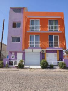an orange and purple house on the side of a street at Vivenda Carlos Daniel in Espargos