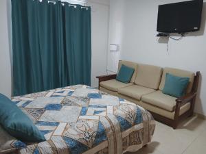 a bedroom with a bed and a couch and a television at Vivenda Carlos Daniel in Espargos