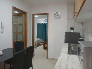 a room with a table and a clock on the wall at Vivenda Carlos Daniel in Espargos +7 photos