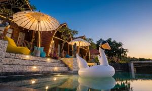 a swimming pool with a swan in the water at Permata Hill Nusa Penida in Nusa Penida