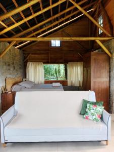 a white couch in a room with a bed at Morada da Mata in Candelária