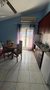 a kitchen with a table and a dining room at Konak Vukojević in Šušanj
