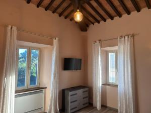 a room with two windows and a tv and a dresser at Casale Il Terranova in Cortona