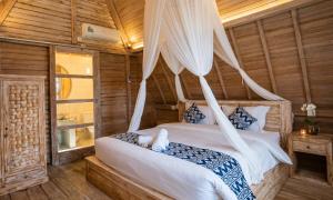 a bedroom with a bed with a mosquito net at Permata Hill Nusa Penida in Nusa Penida
