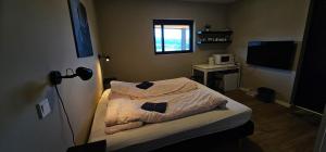 mała sypialnia z łóżkiem i telewizorem w obiekcie Relaxing accomodation w mieście Tau