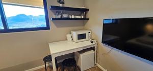 małe białe biurko z kuchenką mikrofalową i oknem w obiekcie Relaxing accomodation w mieście Tau
