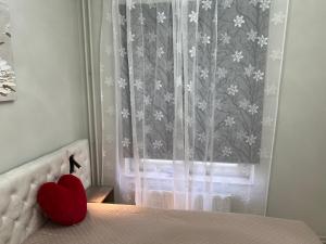 a red heart sitting on a bed with a window at Modern Apartment i Solna in Solna