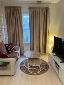 a living room with a couch and a table and a television at Modern Apartment i Solna in Solna