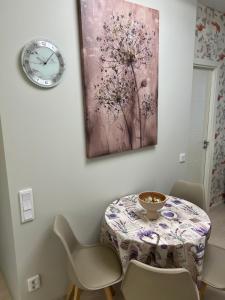 a table with chairs and a clock on a wall at Modern Apartment i Solna in Solna