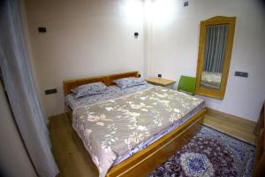 a bedroom with a bed and a mirror at MAHARANI Hotel in Khatīma +4 photos