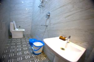 a bathroom with a sink and a toilet at MAHARANI Hotel in Khatīma