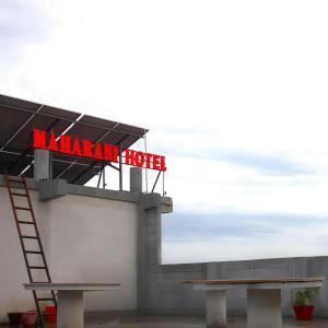 a kalamain hotel sign on a building with a bench at MAHARANI Hotel in Khatīma