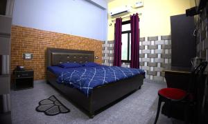a bedroom with a bed and a brick wall at MAHARANI Hotel in Khatīma