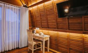 a wooden room with a table and a television on a wall at Permata Hill Nusa Penida in Nusa Penida