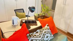 a living room with orange pillows on a couch at Artzy's Garden View 1km to Olivedale Clinic in Northriding