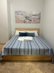a bed in a bedroom with three paintings on the wall at El mar in Ventimiglia