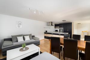 a living room and kitchen with a couch and a table at Maisonette-Apartment mit großer Terrasse im Zentrum von Bregenz in Bregenz