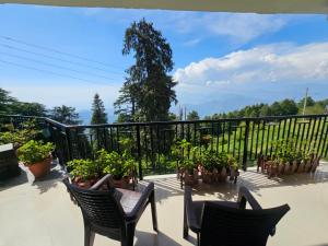 a balcony with chairs and potted plants and a fence at Smarthill-Green Forest View in Dalhousie +43 photos