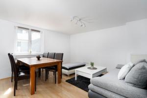 a living room with a table and a couch at Maisonette-Apartment mit großer Terrasse im Zentrum von Bregenz in Bregenz +16 photos