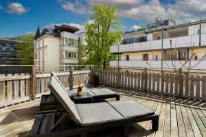 a patio with a bench and a table on a balcony at Maisonette-Apartment mit großer Terrasse im Zentrum von Bregenz in Bregenz