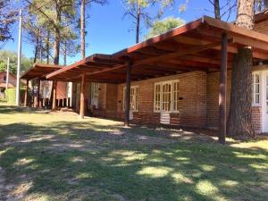 a brick building with a roof on a yard at Complejo Aldea Champaqui in Villa General Belgrano +22 photos