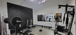 a room with a gym with weights and machines at INN My Place in Selargius