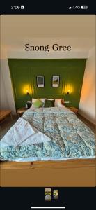 a bed with a green headboard with the words stronggee at Snong-Gree Motel and Restaurant in Rupa