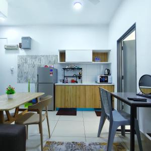 a kitchen with a table and a refrigerator at Studio at Mesahill Nilai by D'KAY HOMES with Mall, near USIM KLIA in Nilai