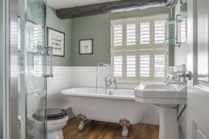 a bathroom with a tub and a sink and a toilet at The King's Arms in Hawkshead